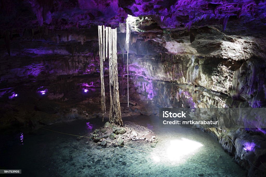 Cenote (lake in cave) Lake under the ground in a cave (Cenote) in Mexico. Beautiful light beam. Blue Stock Photo