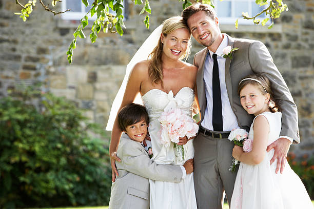 Newly Married Couple With Bridesmaid And Page Boy At Wedding Bride And Groom With Bridesmaid And Page Boy At Wedding Smiling To Camera bride hugging father on wedding day stock pictures, royalty-free photos & images