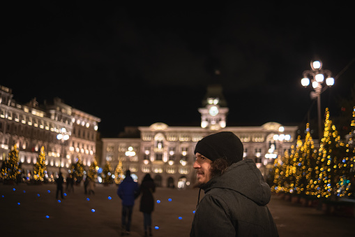 Man walking around decorated town's square with seasonal decoration on