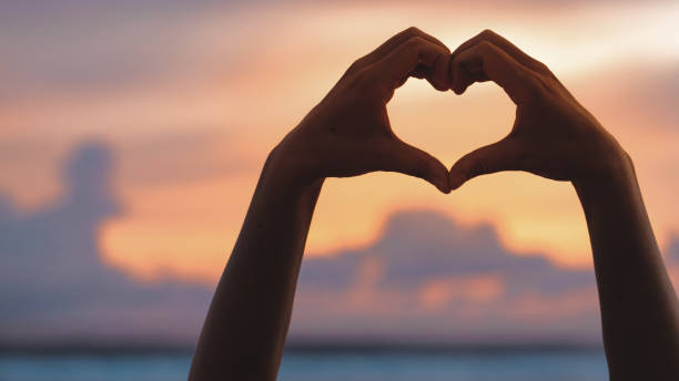 istock Hands forming a heart shape with sunset silhouette 1847551797