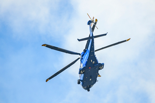 Hamburg, Germany - August 13. 2023: An ADAC rescue helicopter abseils down an emergency doctor over a residential area. On the outskirts of Hamburg