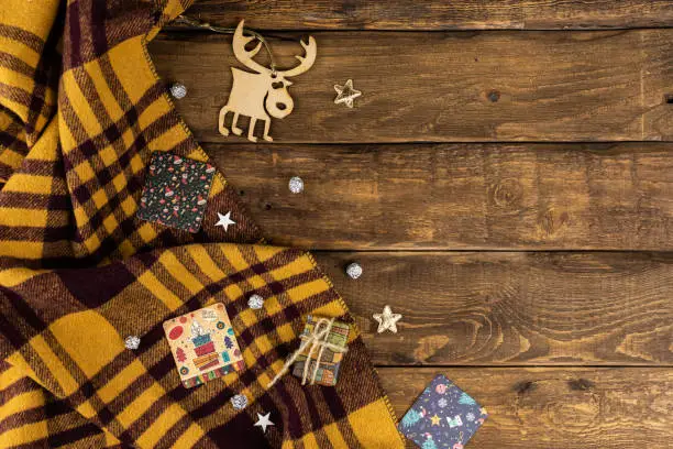 Wooden Background with yellow an d brown plaid with christmas attributes, giftcards, deer, stars