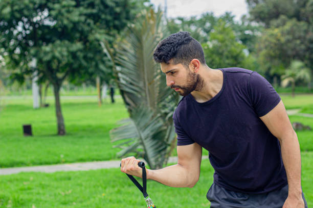 istock young man training with elastic bands, doing arm exercise outdoors in a park 1847589056