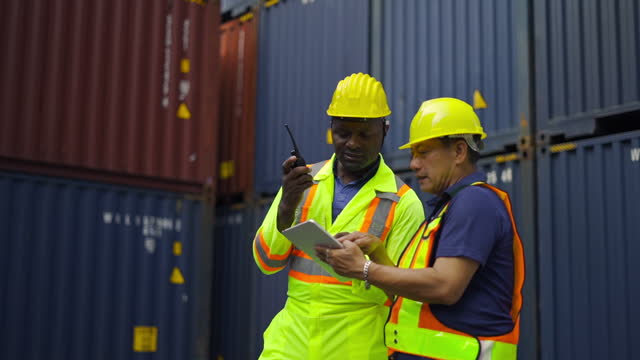 Team logistics staff or engineers inspecting and meeting in front of containers cargo  in the shipping transport area.