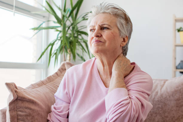 불행한 60 세 여성은 집에서 통증이있는 목이 있습니다. - 60 65 years 이미지 뉴스 사진 이미지