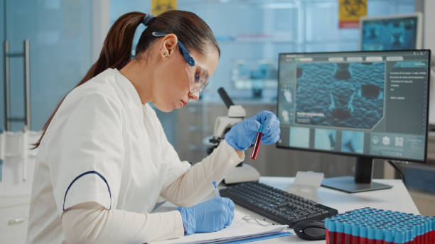 istock Woman scientist looking at test tube and taking notes 1847639217