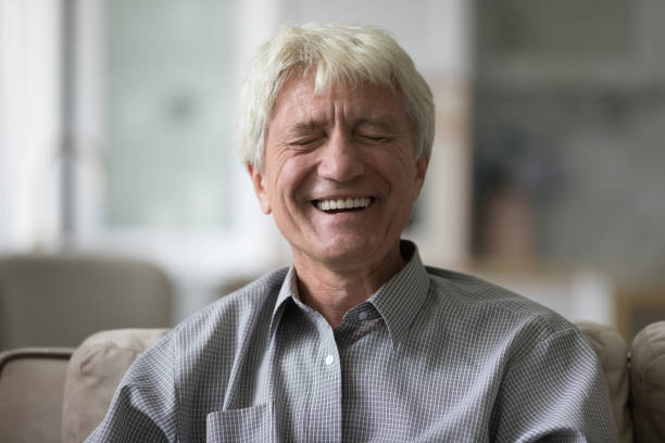 istock Cheerful mature old man laughing at camera with closed eyes 1847656356
