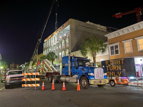 Charleston South Carolina - USA, November 29, 2023. Night time building construction with cranes on King Street downtown Charleston South Carolina. Heavy lifting construction after hours to minimize traffic impact in downtown.