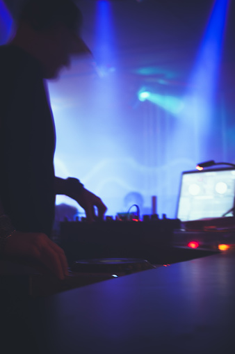Backlit DJ in front of turntables