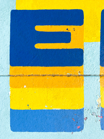 close up painted letter E on a concrete wall texture