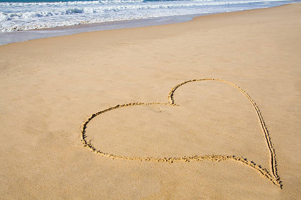 istock heart drawn in the smooth beach sand 184773137