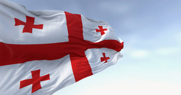 National flag of Georgia waving in the wind on a clear day National flag of Georgia waving in the wind on a clear day. White with a red cross, four smaller crosses in each quadrant. 3d illustration render. Fluttering fabric georgia flag country stock pictures, royalty-free photos & images