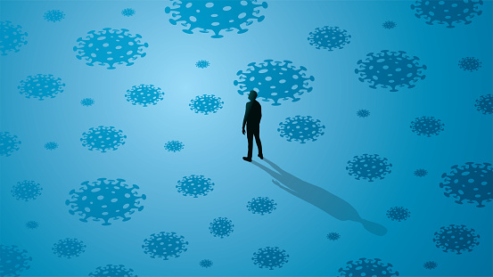Man standing alone in the middle of covid viruses around him.