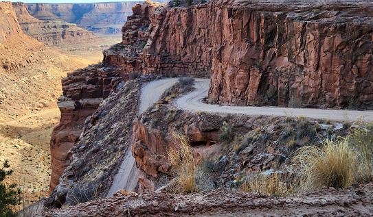 This stunning photo captures the rugged beauty of Shafer Switchbacks in Moab, Utah. The winding road cuts through the red rock canyon, offering breathtaking views of the desert landscape. This is a perfect spot for off-roading, hiking, and enjoying the natural wonders of the American Southwest.