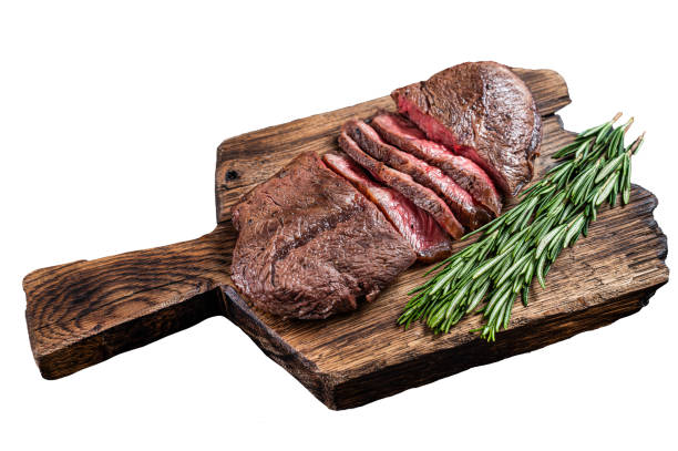ローズマリーを添えた木の板に揚げたトップブレードまたはフラットアイアンローストビーフミートステーキ。 孤立した白い背景。 - chuck steak ストックフォトと画像