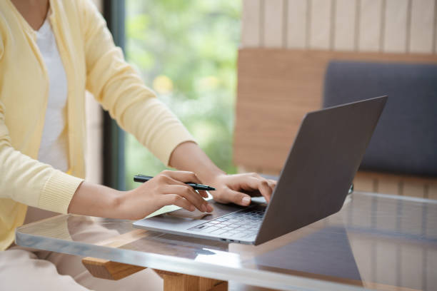 istock Close-up businesswomen using laptop computers to work attentively on a table with various documents such as charts and graphs of important financial data. 1847829590