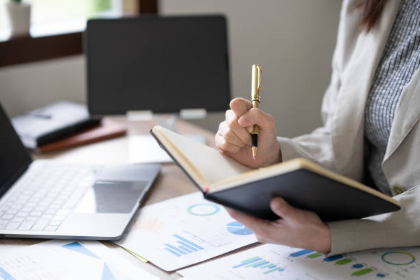 istock Close-up businesswoman sitting taking notes intensively and doing assigned tasks happily and purposefully. 1847830202