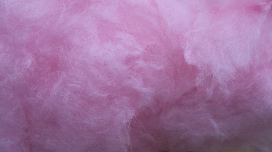 pink background of fluffy weightless material close-up, fluffy texture of lilac cotton candy macro view, delicate fibers of shaggy fabric as texture initially airy monochromatic abstraction
