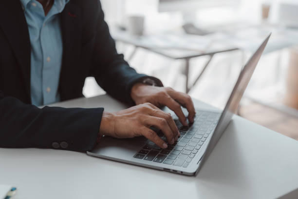 istock Businessman using laptop computer keyboard at the office. 1847834416