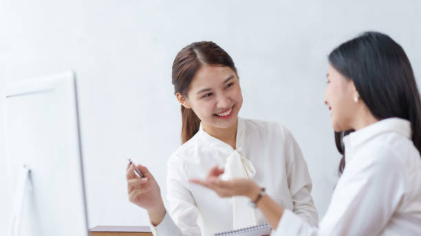 istock Two beautiful Asian young business women discuss work exchange idea exchange knowledge using laptop computer in the office. 1847834946