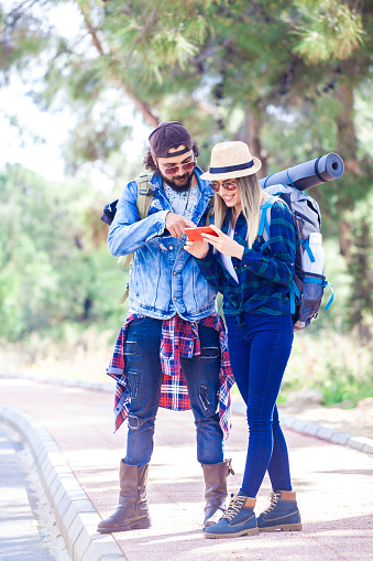 Tourist couple using maps on smartphone in the city. Couple sightseeing the city. Couple backpacker looking at mobile phone.