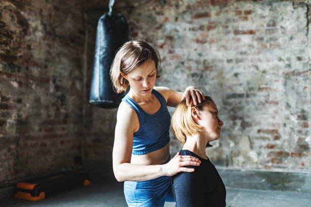 istock Yoga therapist helping her client with neck pain 1847930647