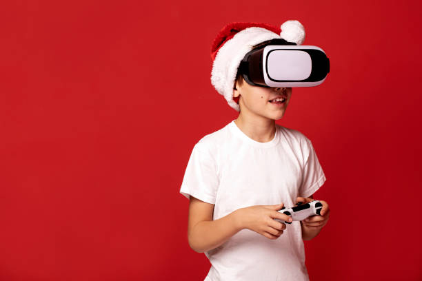 istock Fascinated little boy in santa claus red hat using VR virtual reality goggles. 1847974701