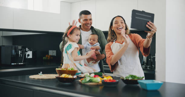 istock Tablet, family smile and video call while cooking, happy and internet on technology, communication and greeting. Parents, people or children, hello and networking or connection, conversation and wave 1848020294