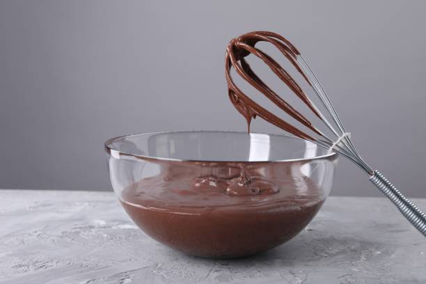 istock Bowl and whisk with chocolate cream on table against grey background 1848029782