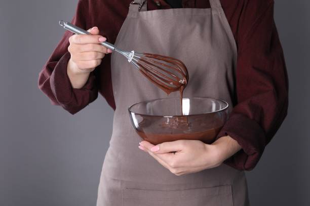 istock Woman with whisk making chocolate cream on grey background, closeup 1848029795