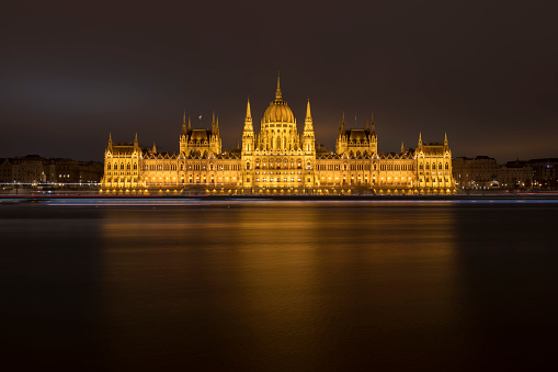 Budapest, Hungary - December 8, 2023: night view of the Hungarian parliament building, Országház. No people are visible, long exposure makes a silk effect on water.