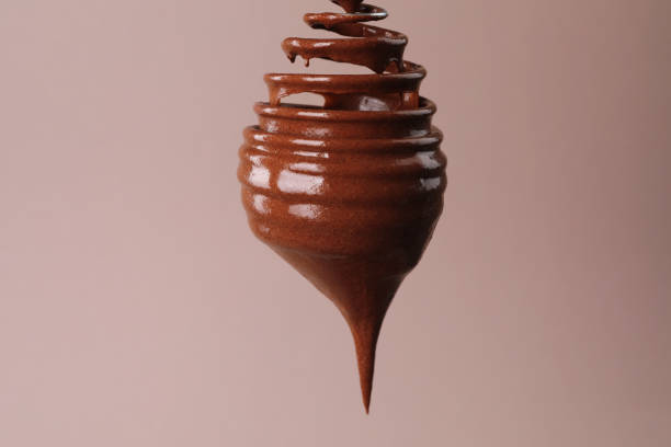 An elevated, close-up shot of a white rectangular platter displaying numerous identical chocolate truffles. Each bite-sized sphere is coated in dark chocolate with small, stick-like adornments, arranged in neat rows.