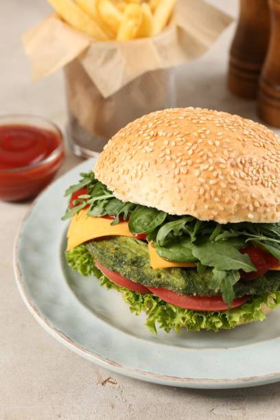 istock Tasty vegetarian burger with spinach cutlet, cheese and vegetables served on white table, closeup 1848045823