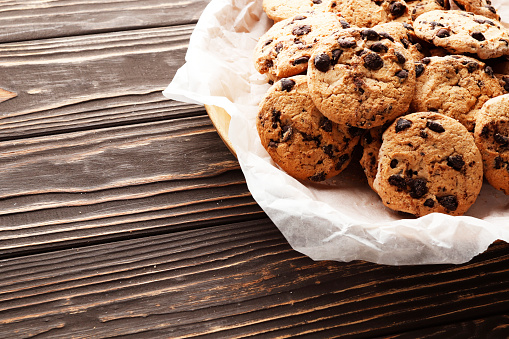 close-up image of chocolate chips cookies on a wooden background. Place for text. Top view.