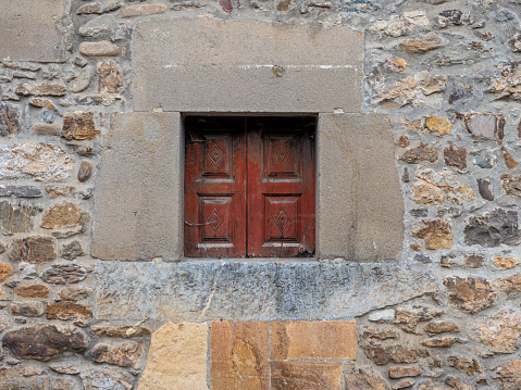 Old stone wall with window and grille