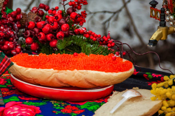 Red caviar is spread on bread with a thick layer. Maslenitsa street fair. Outdoor food
