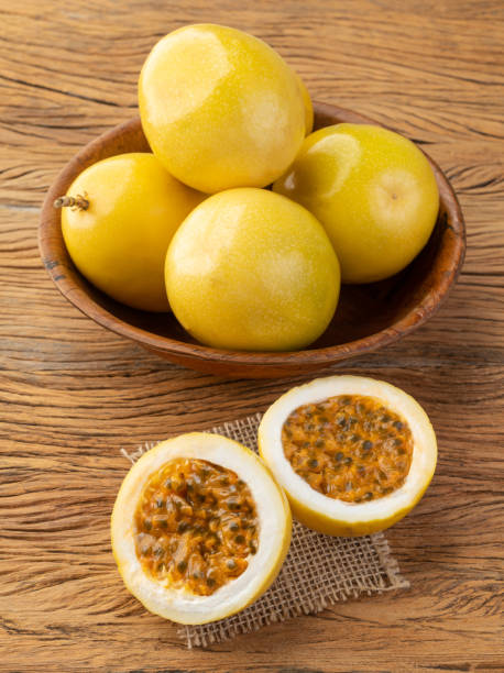 istock Passion fruits in a bowl with cut fruit over wooden table 1848072704