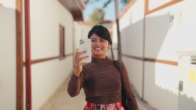 Multi-racial female tourist visiting old ancient town and taking photos and videos with her mobile smart phone