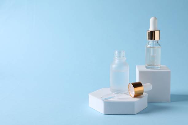 istock Presentation of bottles with cosmetic serums on light blue background, space for text 1848091430