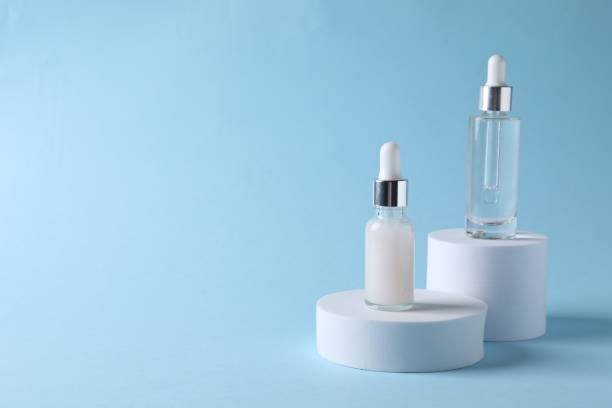 istock Presentation of bottles with cosmetic serums on light blue background, space for text 1848091461