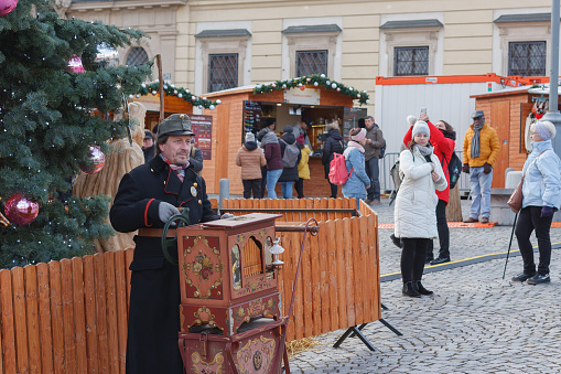 Brno, Czech Republic-November 26, 2023: Man with barrel organ  at Christmas market on the Cabbage Market on November26, 2023 Brno, Czech Republic