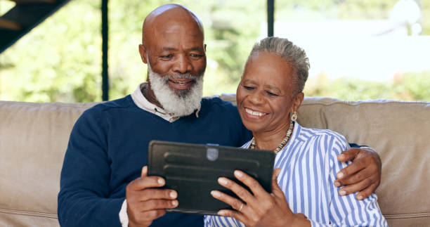 istock Tablet, video call and senior couple on a sofa for web communication, network or chat at home. Digital, app and old people in living room with love, social media or streaming subscription in a house 1848098524