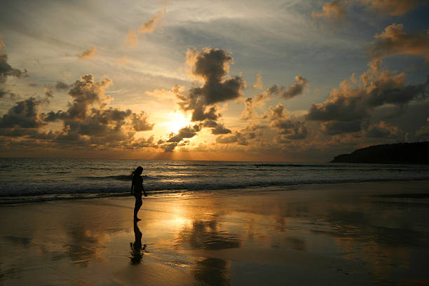 istock Women walking alone on the beach when the sun was falling. 184812227