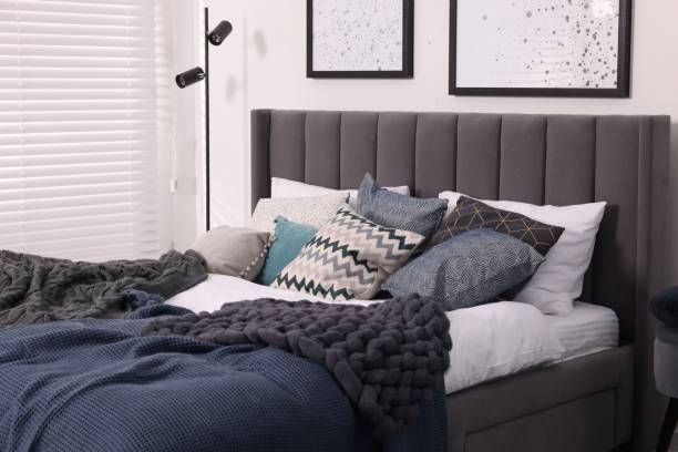 istock Large comfortable bed with soft pillows and blankets in room. Home textile 1848124429
