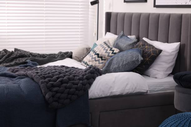 istock Large comfortable bed with soft pillows and blankets in room. Home textile 1848124955