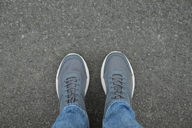 istock Man in sneakers standing on asphalt, top view 1848156565