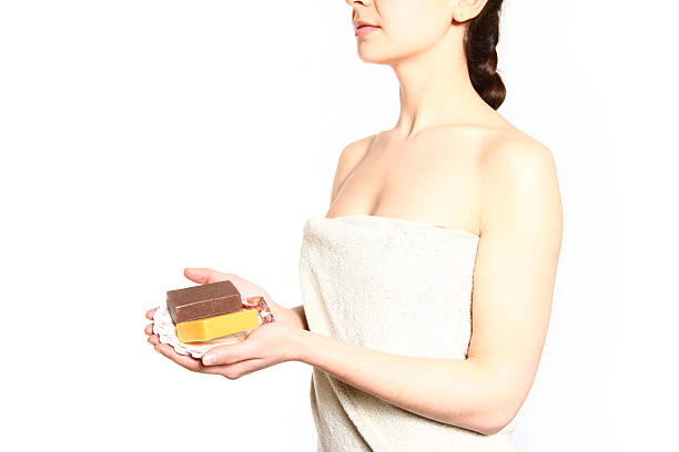 istock Young woman with towel holding soap isolated on white background 184817662