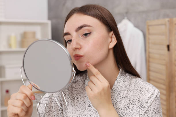 istock Young woman with skin problem looking at mirror in bathroom 1848176668