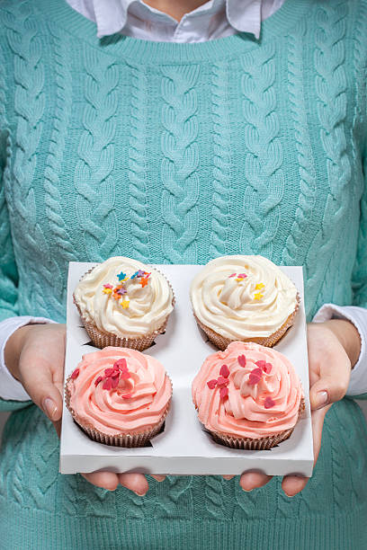 istock woman holding cupcakes in hands 184819257