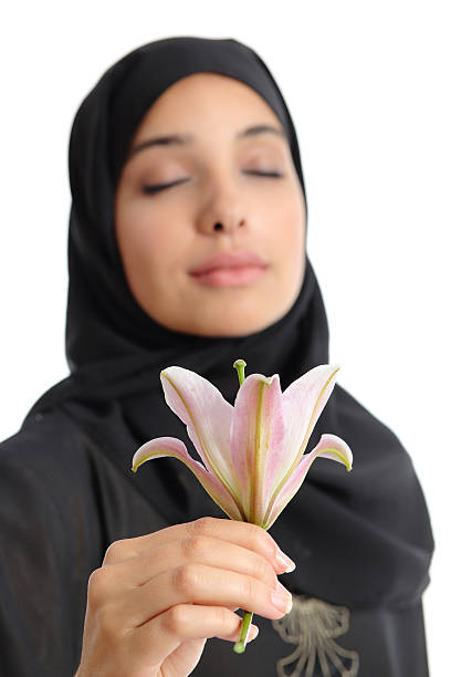 linda mulher árabe usando um hijab a cheirar as flores - close to moving up single flower flower imagens e fotografias de stock